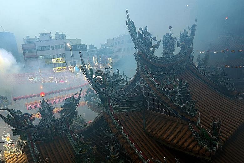 Smoke from burnt offerings and incense shrouding the Matzu temple during a ceremony in Taiwan last month. The island's temples are playing firecracker CDs and encouraging worshippers to clap hands to create smoke-free noise.