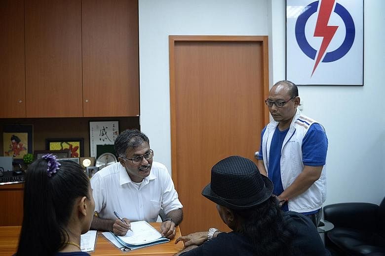 (Above) Mr Murali speaking with a resident during his first Meet-the-People Session at the Bukit Batok PAP branch office last night. (Left) He was sworn in as MP for the constituency at Parliament House earlier in the day.