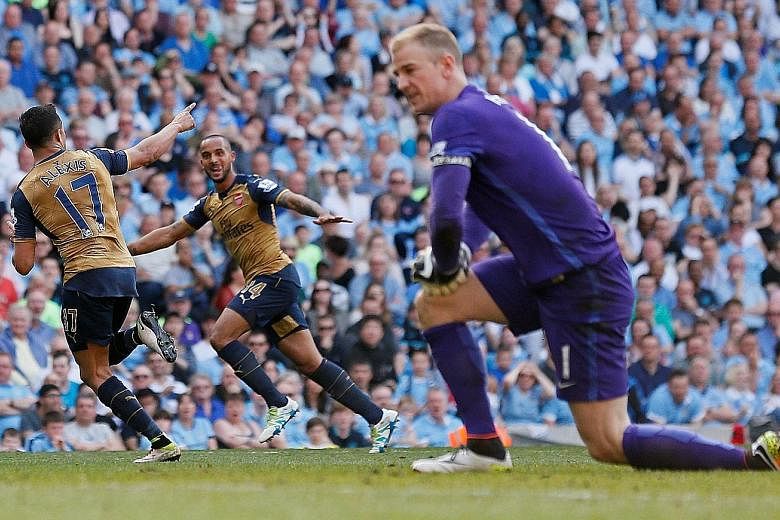 Above: Alexis Sanchez (left) celebrates scoring the second equaliser for Arsenal with Theo Walcott, as Man City goalkeeper Joe Hart looks on dejected. Left: Despite a half-empty stadium, City manager Manuel Pellegrini still applauds the fans for thei