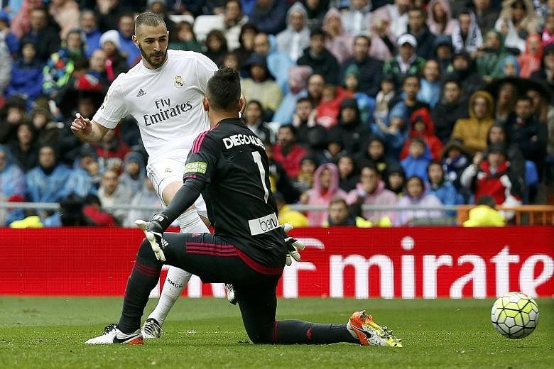 Real Madrid striker Karim Benzema scores their second goal against Valencia on Sunday. Real won the La Liga clash 3-2 to set up a chance to overtake league leaders Barcelona on the final day of the league competition next Saturday.