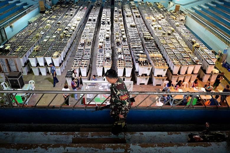 A soldier patrolling near election paraphernalia at Almendras Gym in Davao city, on the southern Philippine island of Mindanao, yesterday. In Monday's presidential election, Mr Duterte beat four other candidates after winning the support of the middl