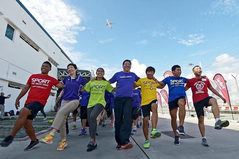 Ms Fu (second from left), FedEx Express Singapore's managing director Khoo Seng Thiam (centre) and SportSG's chief of strategic development and marketing group Toh Boon Yi (extreme right) at a morning workout with SportSG employees and FedEx Express 