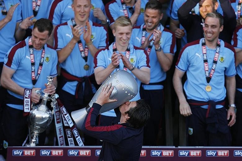 Burnley's Joey Barton pointedly celebrates with a blow-up trophy on Monday, after a shortfall of two Championship winners' medals meant that he and James Tarkowski missed out. The club apologised for the error and the players were finally given their