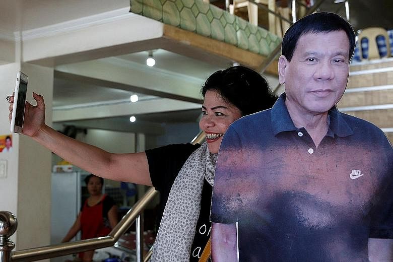 An admirer taking a selfie with a cut-out image of Mr Duterte at a restaurant in Davao city, southern Philippines.