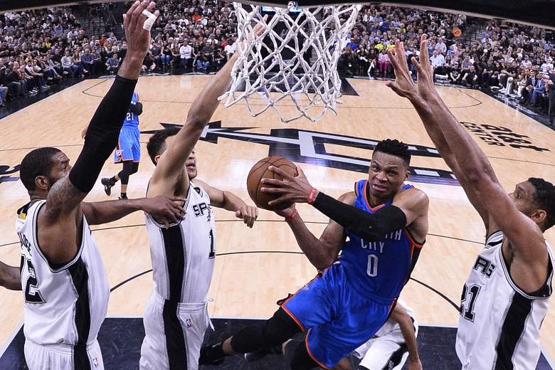 Oklahoma City Thunder player Russell Westbrook (centre) going to the basket in the first half against the San Antonio Spurs on Tuesday. The 27-year-old, through his unmatched competitive spirit and force of will, sparked the Thunder in the second half to 