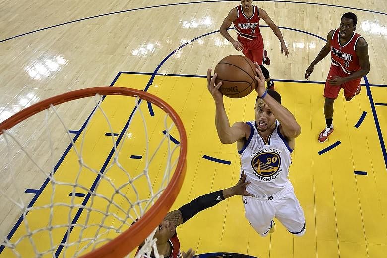Golden State Warriors star Stephen Curry, the newly- crowned league Most Valuable Player, powering ahead of Portland Trail Blazers players to score two of his 29 points in Game 5 of the NBA Western Conference semi-finals. The Warriors won the series 