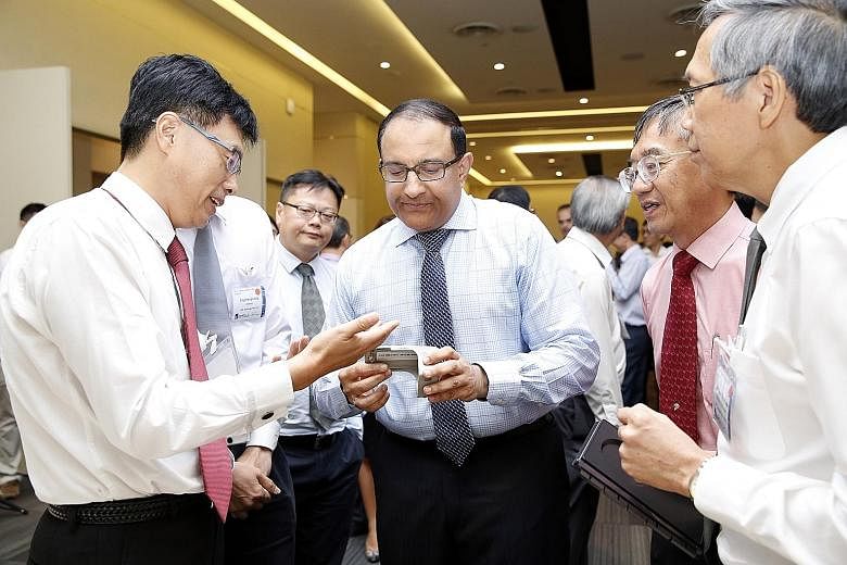 Mr Iswaran checking out an exhibit at the Precision Engineering Centre of Innovation conference yesterday, where he stressed the importance of technology and innovation for the sector to grow and stay competitive.