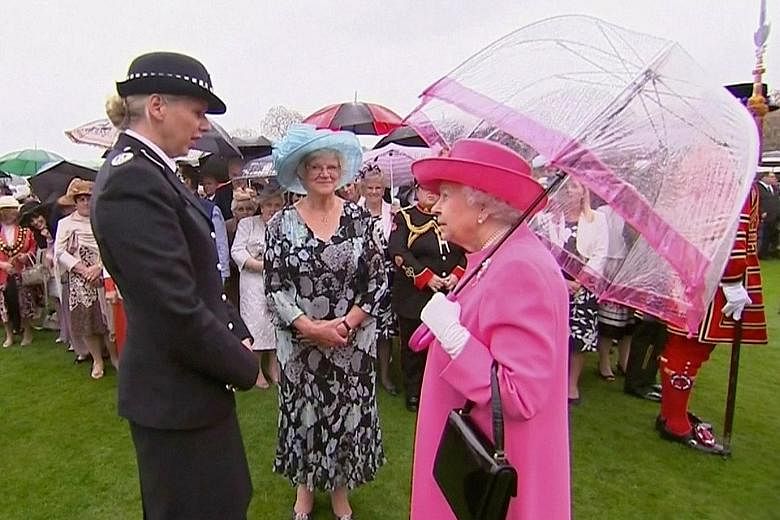 Queen Elizabeth with Commander Lucy D'Orsi (in uniform) at Buckingham Palace. British media reported yesterday that the Queen's umbrella was to blame for causing comments she made about "very rude" Chinese officials to be picked up by a TV camera. Th