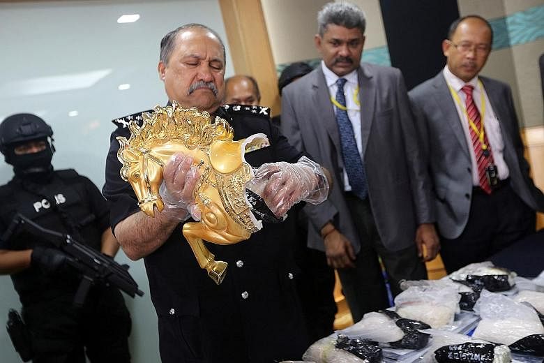 Bukit Aman Narcotics Criminal Investigation Department director Mohd Mokhtar Mohd Shariff showing the horse statuettes being used to smuggle packets of syabu, a party drug, at a press conference in Kuala Lumpur yesterday. A 28-year-old Nigerian man w