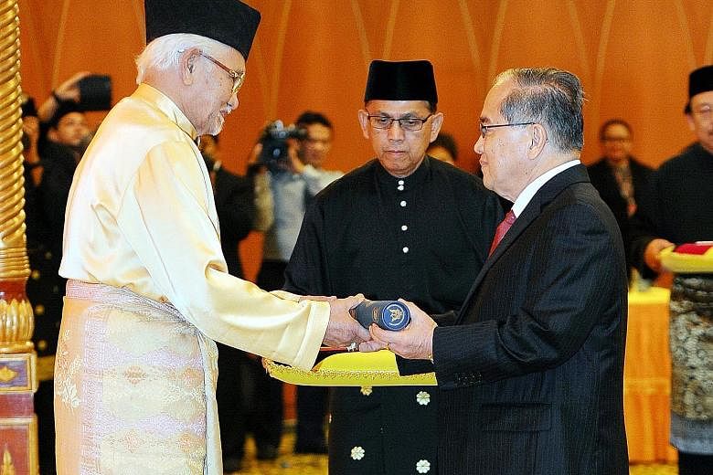 Sarawak Governor Tun Abdul Taib Mahmud (left) presenting the letter of appointment as a member of the Sarawak Cabinet to Datuk Amar Douglas Uggah Embas during the swearing-in ceremony at the Sarawak State Legislative Building yesterday.