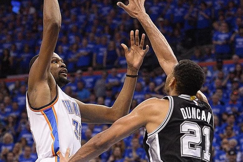 Oklahoma City forward Kevin Durant shoots over San Antonio forward Tim Duncan as Spurs guard Manu Ginobili looks on. The Thunder overcame the Spurs 113-99 and will next face Golden State.