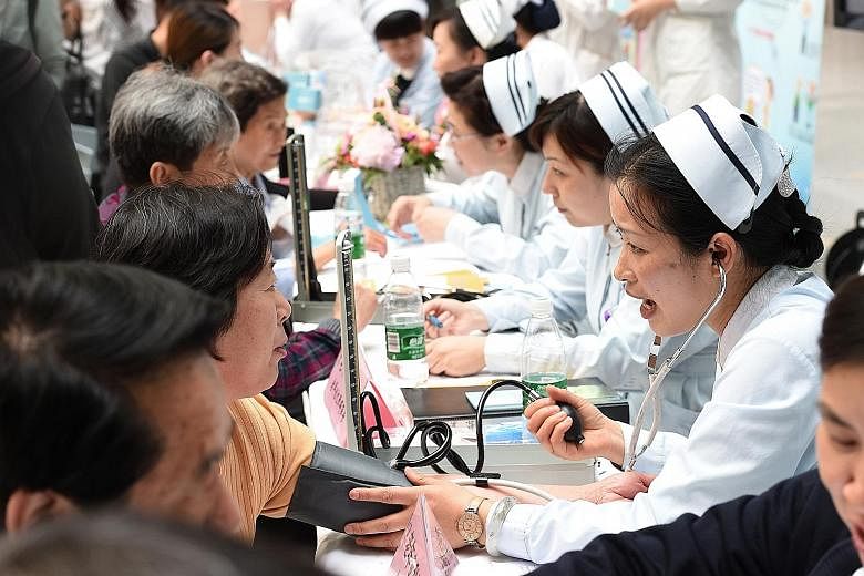 Nurses in Nanjing city conducting free health screening services for residents. The country's healthcare system is overstretched and the distribution of resources is unbalanced. The public also has limited access to information related to health and 