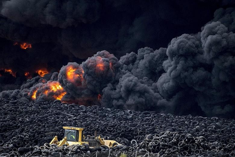 Flames raging through a pile of tyres at a massive waste ground south of the Spanish capital of Madrid yesterday. The 10ha dump, which contains millions of tyres, caught fire early yesterday morning, releasing a thick black cloud of toxic fumes. Offi