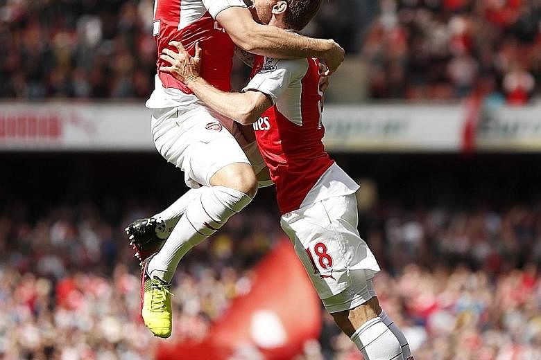 Olivier Giroud (left) celebrating with Nacho Monreal after scoring Arsenal's first goal. The Frenchman enjoyed a hat-trick in the 4-0 win, which maintained Arsene Wenger's record of always finishing above Spurs in the league.
