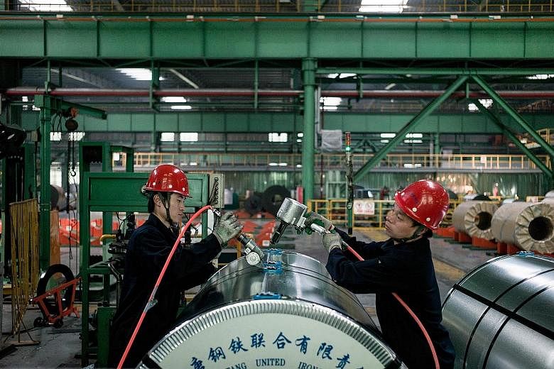 Chinese workers packing steel rolls in a factory in Tangshan, Hebei province. China's economic growth has cooled to 25-year lows, weighed down by a combination of weak demand at home and abroad, factory overcapacity and increasing amounts of debt.