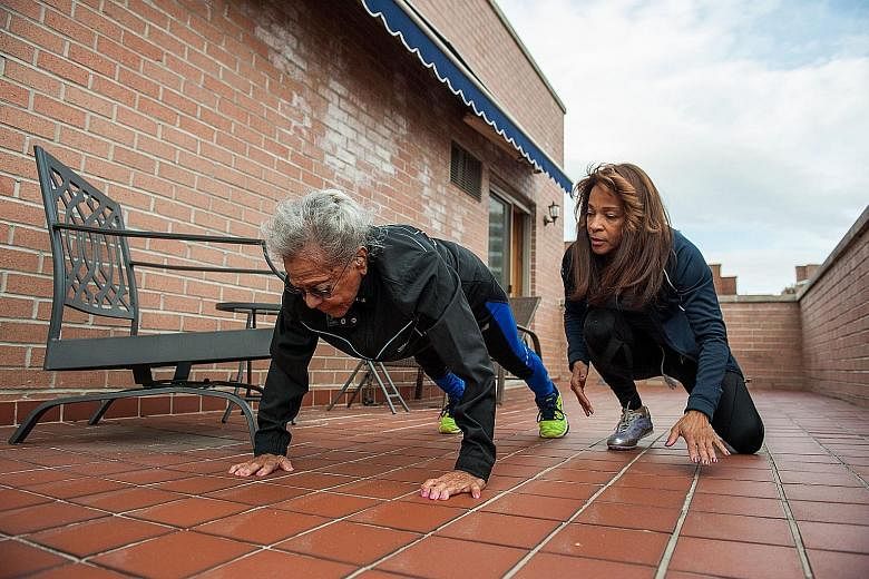 Ms Shelley Keeling watching her mother, Ms Ida Keeling, doing push-ups. To maintain her health, the centenarian follows a stringent regimen of diet and exercise.