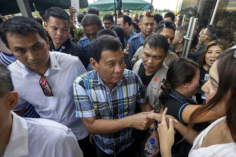 Mr Duterte (left) greeting supporters yesterday in Davao. The Philippine leader said he would give security forces "shoot-to-kill" orders for organised criminals or those who resist arrest violently.