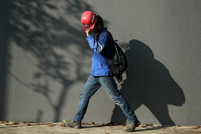 A worker using his helmet to shield himself from the sun. Last month was the hottest April in Singapore since 1929, says Meteorological Service Singapore.