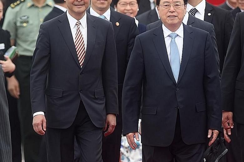Mr Zhang (at right) accompanied by Mr Leung after arriving at Hong Kong's airport yesterday. Mr Zhang is the most senior Chinese official to visit Hong Kong since the 79-day Occupy movement in 2014 to push for unfettered elections.