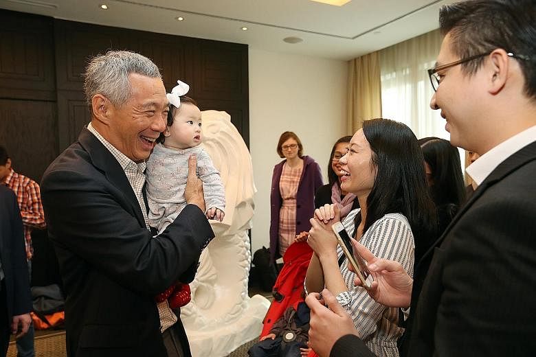 PM Lee meeting Singaporeans Derrick and Melissa Leow, both 32, at a reception in Moscow yesterday. He is holding their seven-month-old daughter, Charlotte. He will fly to Sochi tomorrow to attend the Asean-Russia Commemorative Summit, which marks 20 