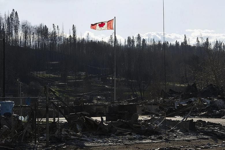 Damage caused by a wildfire that swept through some neighbourhoods in Fort McMurray, Alberta, last Saturday. The latest mandatory evacuation alert covered 12 work camps north of the city.