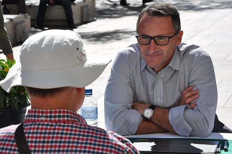 Dr Di Natale talking to a voter in Perth last week. The sports-obsessed farmer and former medical doctor has sought to give the Greens a fresh, modern image after becoming their leader last year.