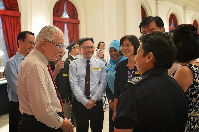President Tony Tan Keng Yam speaking to civil servants, including Immigration and Checkpoints Authority Checkpoint Inspector (2) Zarina Zainee at an Istana reception yesterday evening. Some 500 public officers attended this year's reception, hosted b