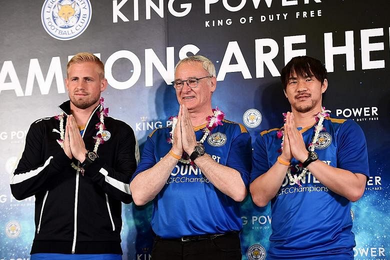 Leicester City goalkeeper Kasper Schmeichel, manager Claudio Ranieri and forward Shinji Okazaki greet the press with a traditional Thai "wai" gesture at the Suvarnabhumi Airport in Bangkok yesterday.