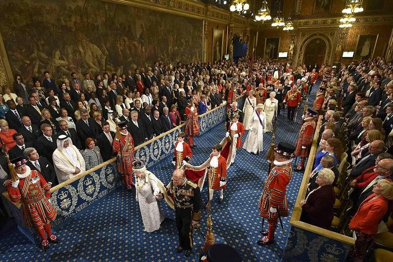 Queen Elizabeth and Prince Philip proceeding through the Royal Gallery before the State Opening of Parliament in the House of Lords at the Palace of Westminster in London yesterday.