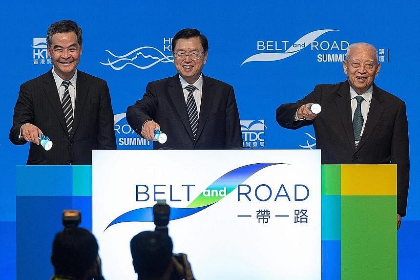 Mr Zhang Dejiang (centre), with Mr Leung Chun Ying (left) and former Hong Kong chief executive Tung Chee Hwa, at the opening ceremony of the Belt and Road Summit in Hong Kong yesterday. Protesters in Hong Kong yesterday demonstrating against the visi