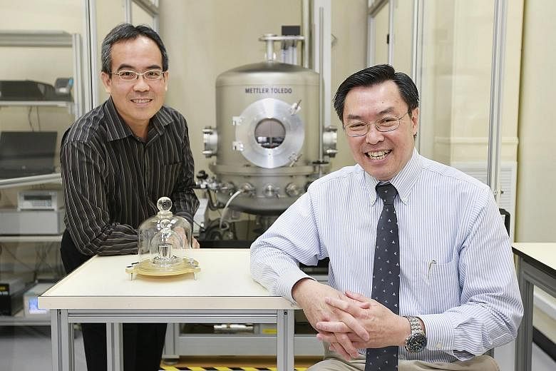 The National Metrology Centre's Mr Lee (far left) and Dr Liew with a 1kg prototype.