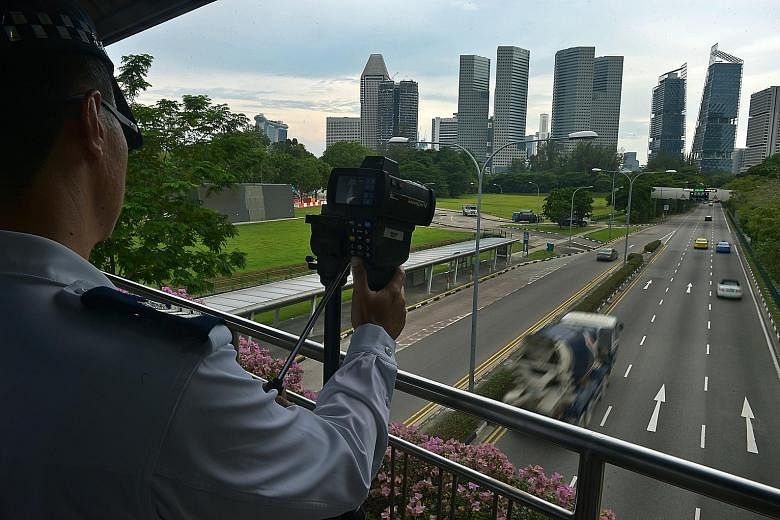 A Traffic Police officer operating the new speed laser camera on a bridge over Nicoll Highway yesterday.