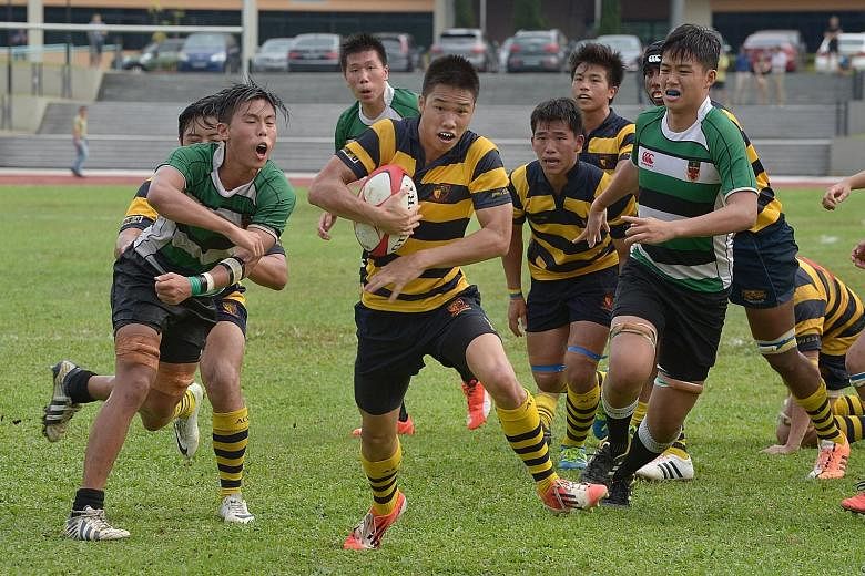 Anglo-Chinese School (Independent)'s Jason Goh (with ball) breaks away to score his side's fourth try in the A Division rugby final against Raffles Institution. ACS(I) secured their third straight A Division crown.