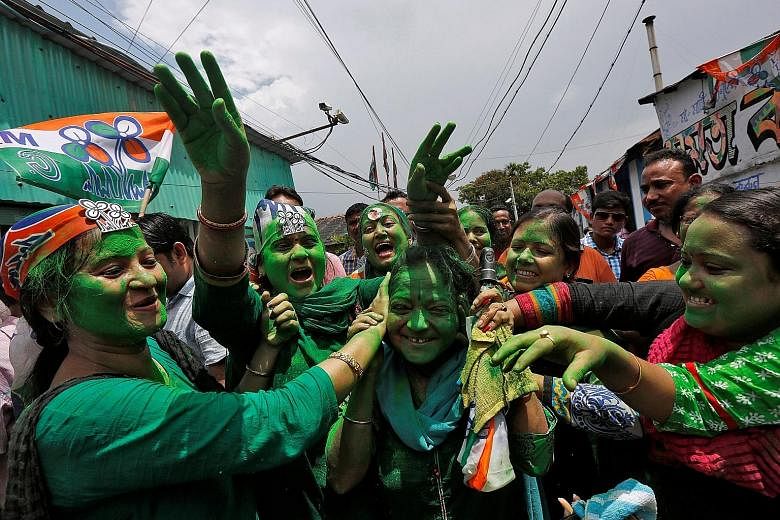 Supporters of Ms Banerjee's Trinamool Congress celebrating in Kolkata yesterday after learning the initial poll results of the West Bengal assembly elections.