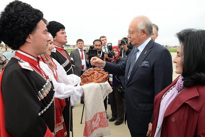Malaysian PM Najib and his wife Rosmah Mansor taking part in the traditional bread and salt welcome ceremony on their arrival at Sochi on Wednesday.