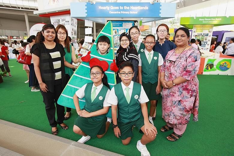 At Bedok Town Plaza's opening are Casuarina Primary School's (kneeling, from left) Diyanah Amani Ismail and Muhd Zharfan Shahrin; (standing, from left) Madam Kaladevi Nadarajah, Ms Ng Wei Hunn, Lee Pin, Madam Maryana Mohamad, Ng Yen Nee, Sufia Namira