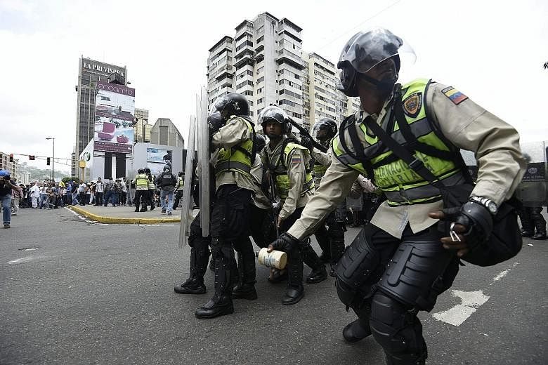 Venezuelan police in a face-off with protesters in Caracas on Wednesday. Rising political and economic tensions are gripping a country beset by record inflation, shortages of basic goods, and currency controls.