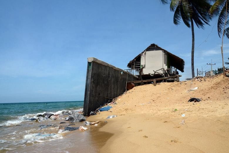  (Above) The only thing between this house in Pattani province and the strong waves is a seawall.