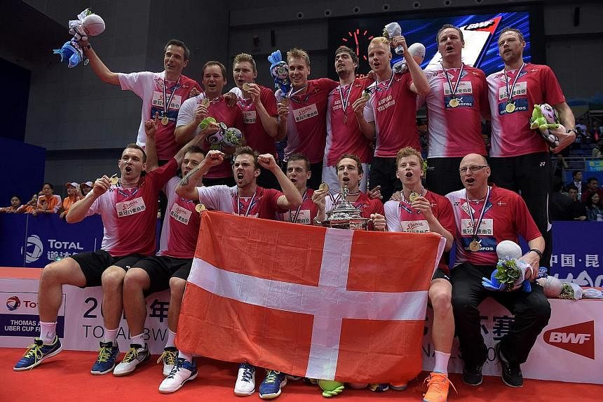 Hans-Kristian Vittinghus (left) pointing to the Danish flag on his shirt in celebration following his 21-15, 21-7 victory over Indonesia's Ihsan Maulana Mustofa to seal Denmark's first Thomas Cup triumph. The Denmark team (above) celebrating with the
