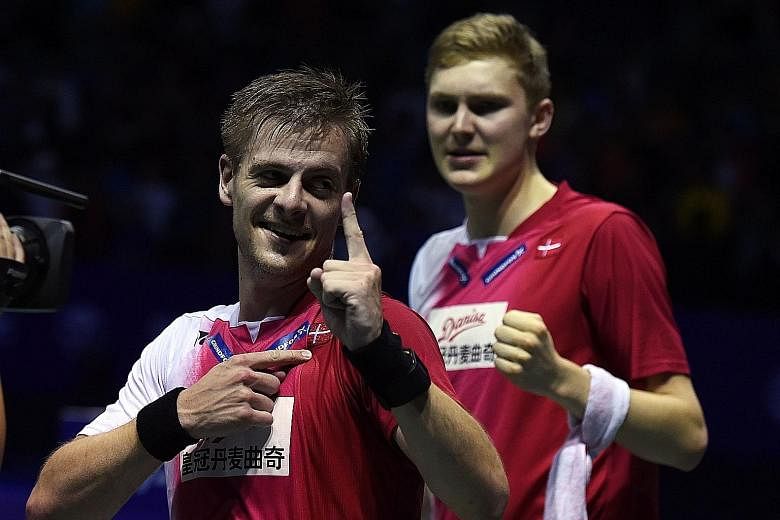 Hans-Kristian Vittinghus (left) pointing to the Danish flag on his shirt in celebration following his 21-15, 21-7 victory over Indonesia's Ihsan Maulana Mustofa to seal Denmark's first Thomas Cup triumph. The Denmark team (above) celebrating with the