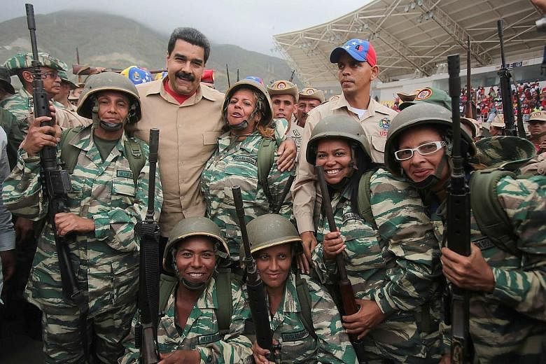 Venezuela's President Nicolas Maduro (back row second from left) posing for a photo with militia members during a military parade in La Guaira, Venezuela, on Saturday. The country held what it called its biggest military exercises on Friday and Satur