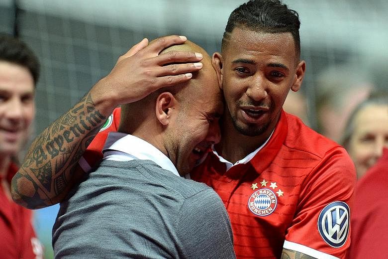 Bayern Munich's outgoing coach Pep Guardiola is comforted by Jerome Boateng after being overwhelmed with emotion following the German Cup final against Dortmund. The Bavarians overcame their fierce rivals to lift the cup, scant reward for missing out