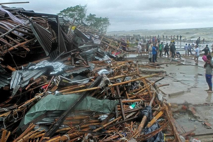 Debris of damaged shops at Patenga Beach in Chittagong after the cyclone hit. About half of those who died were from the Chittagong region which bore the brunt of the storm. Villagers making their way to shelter as Cyclone Roanu approached last Satur