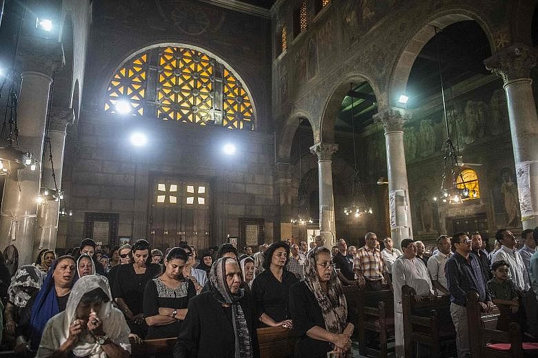 Relatives and friends of the EgyptAir crash victims attending a mourning ceremony yesterday at the Saint Peter and Saint Paul Coptic Orthodox Church in Cairo's Abbasiya district.