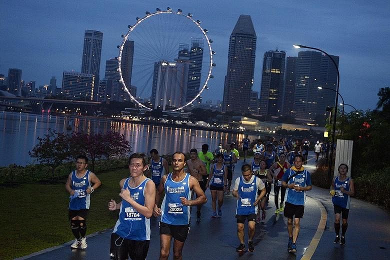 ST Run participants running along Gardens by the Bay East early yesterday morning. The ground may have been wet because of the rain, but their spirits were not dampened. Racegoers later enjoyed themselves at the post-race carnival at the F1 Pit Build