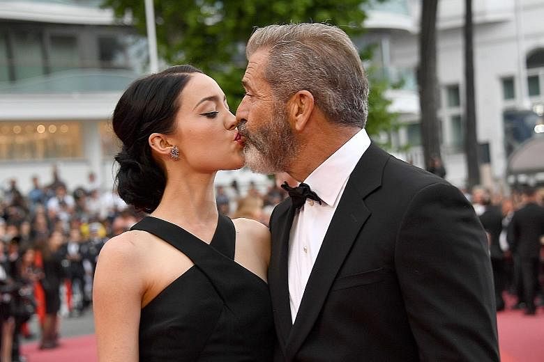 In their rare public appearance together, 60-year-old Mel Gibson walks the red carpet and shares kisses at the closing ceremony with his girlfriend, screenwriter Rosalind Ross (both above).