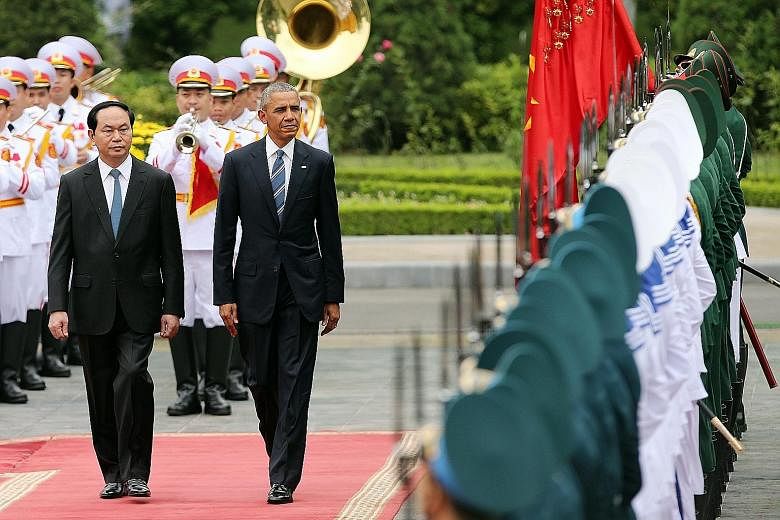President Obama reviewing a guard of honour with President Quang at the Presidential Palace in Hanoi yesterday. Mr Quang said the lifting of the US ban on sales of lethal weapons to Vietnam "is clear proof that both countries have completely normalis
