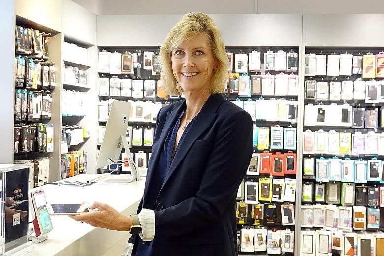 Apple Pay vice-president Jennifer Bailey (above) demonstrating the e-wallet system at the iStudio retail shop in Paragon mall yesterday. The five major banks here that have signed up to the system are POSB, DBS Bank, OCBC Bank, UOB and Standard Chartered 