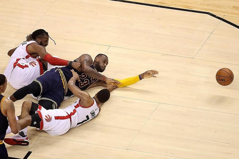 Ferocity on the floor as LeBron James (middle) of the Cleveland Cavaliers competes for the ball with DeMarre Carroll (left) and Kyle Lowry (No. 7) of the Toronto Raptors in Game 4 of the Eastern Conference Finals on Monday. The Raptors won 105-99 to 
