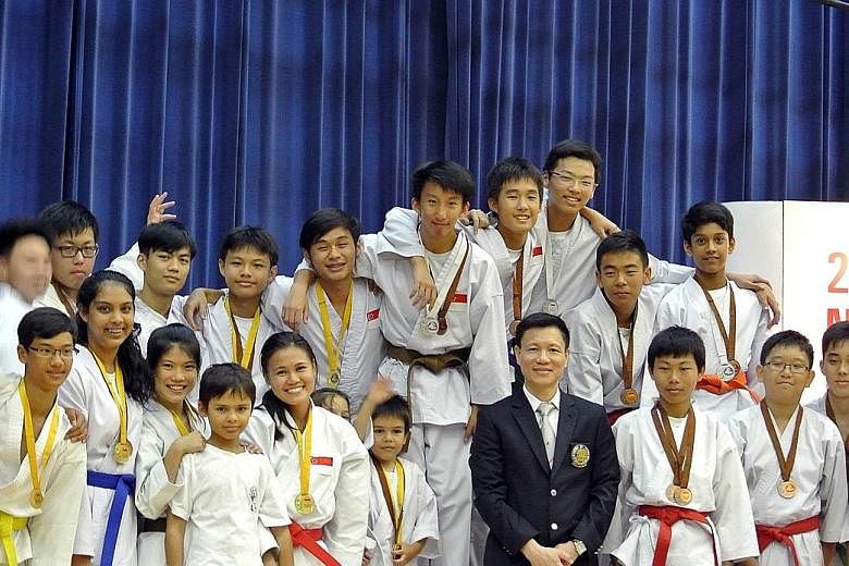 David Thong (in dark jacket) the president of the Singapore Karate-do Federation (SKF), with young competitors. He said the expelled clubs would be welcomed back as affiliates, so as not to overlook talented athletes
